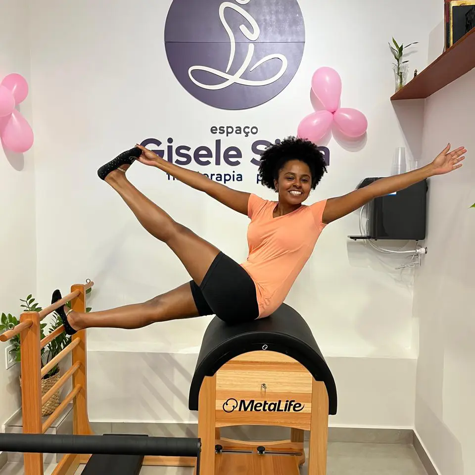 Mulher feliz fazendo pilates no Espaço Gisele Silva